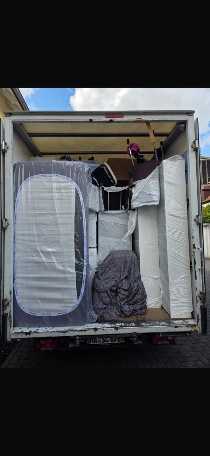 Geöffneter Umzugswagen mit sicher verstauten und verpackten Möbeln.