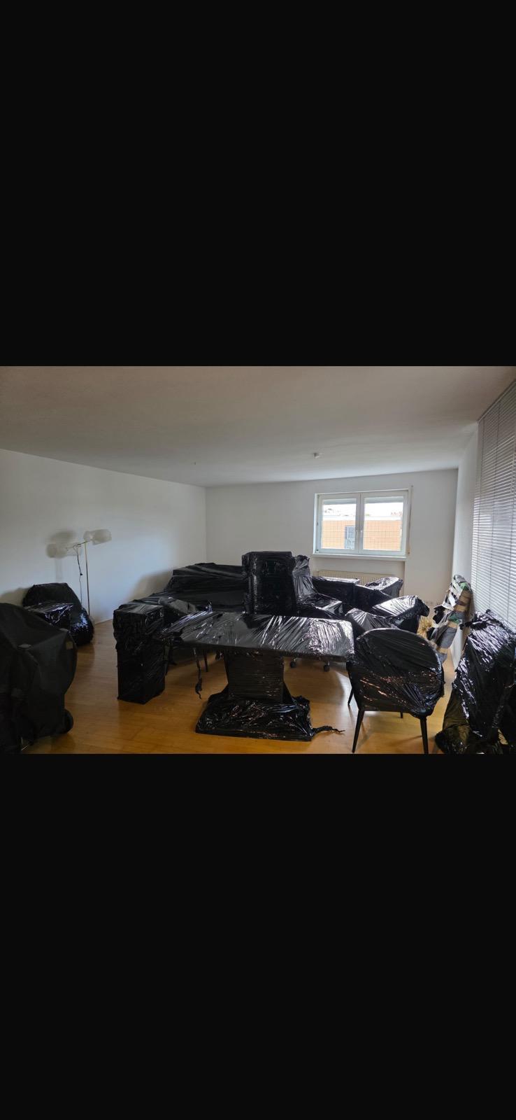 Professionell beladener Umzugswagen mit geschützten Möbeln, Kartons und Haushaltsgeräten.
